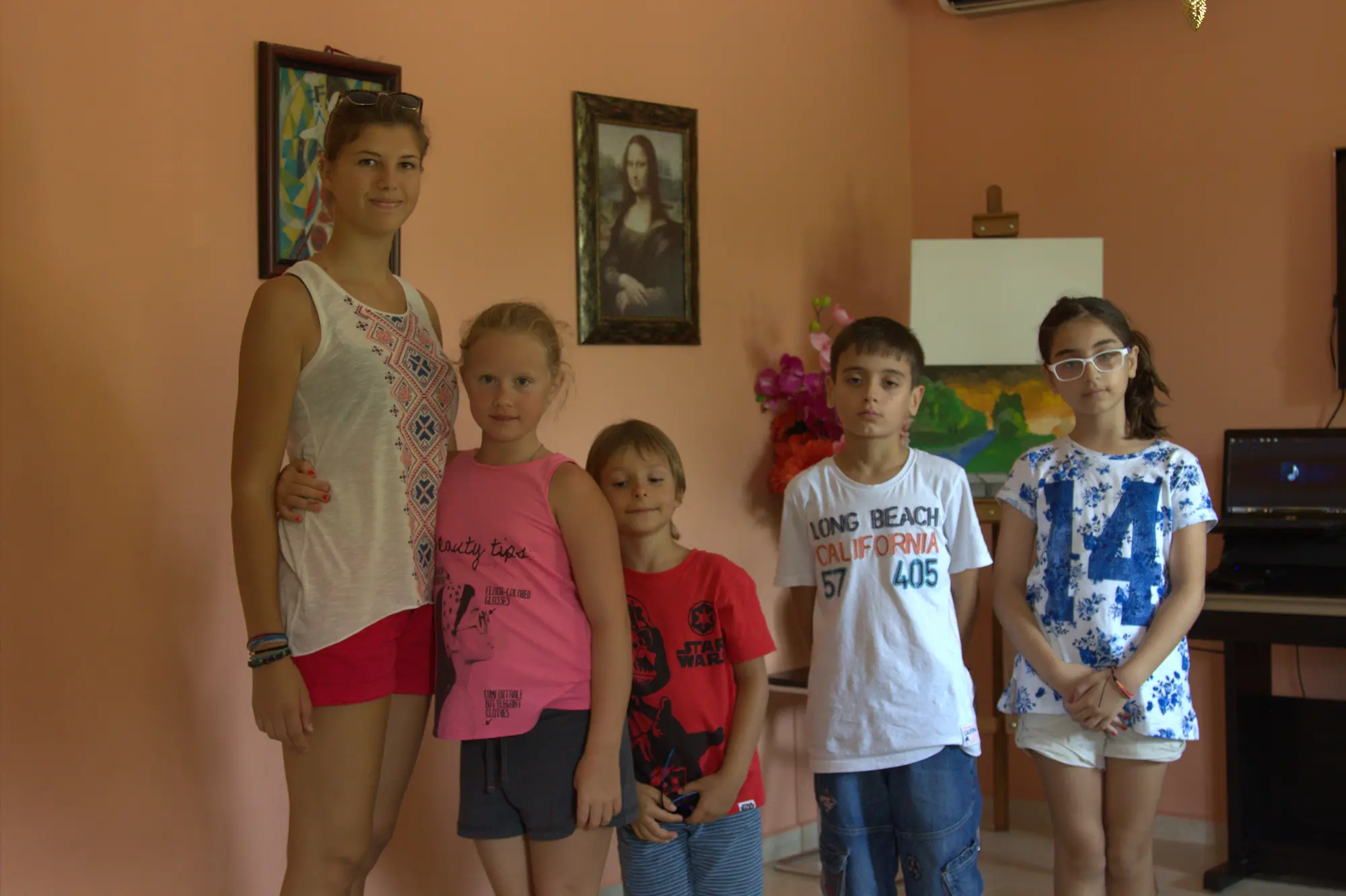 Atölyede eğitmeniyle birlikte poz veren bir grup resim dersi öğrencisi